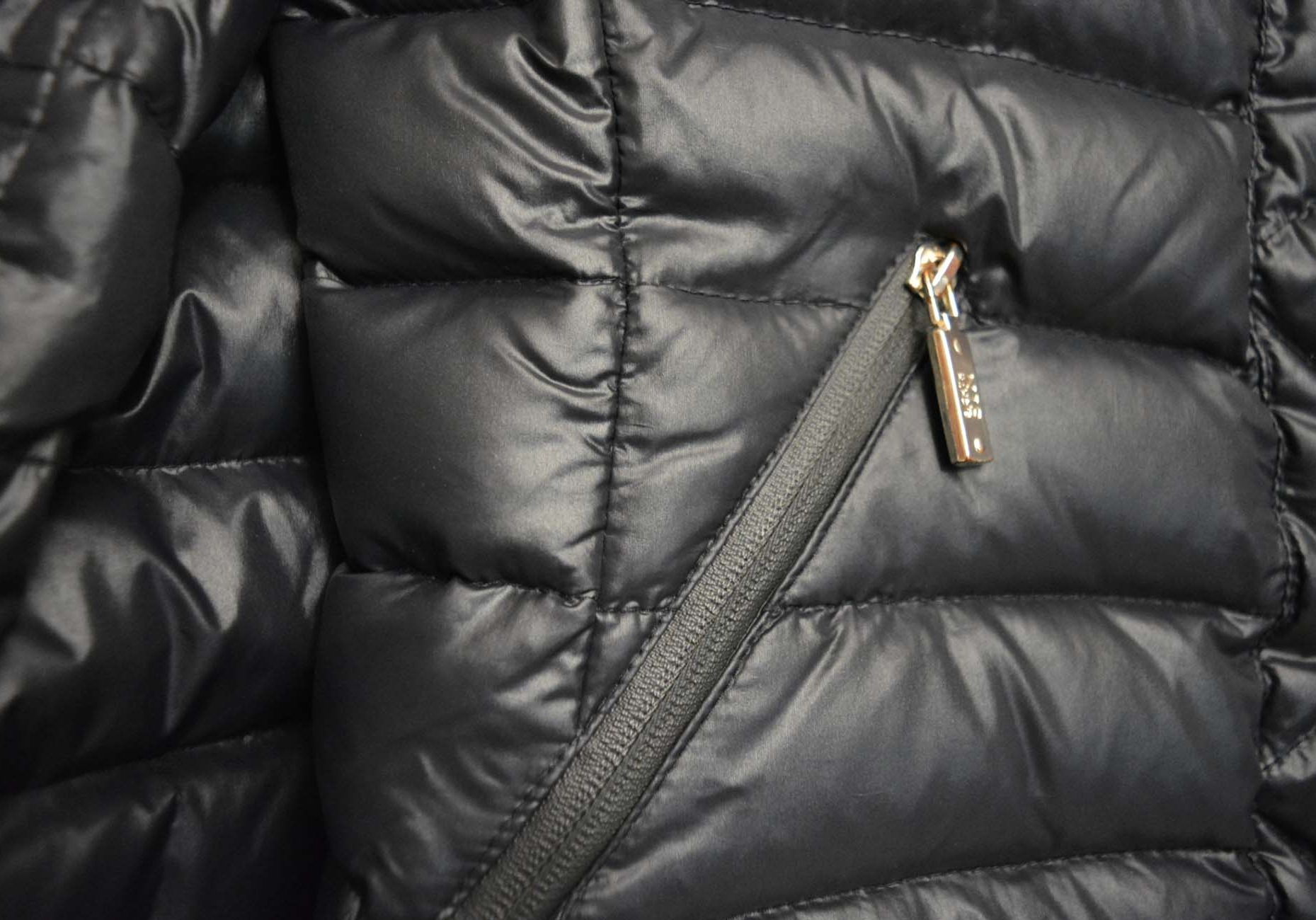 Down Coat Beautiful stylish black women short down jacket with white fluffy puffer jacket hanging on grey stone background. Clothing, outerwear, everyday women s clothes. Black winter jacket with fur hood on a white brick wall background. Detail of a black winter jacket with a metal buckle and chain. Women s winter jacket on a hanger in a room with a brick wall. Close up of a black jacket with fur collar and buttons on it. Close up of a black winter jacket with a key in the pocket.